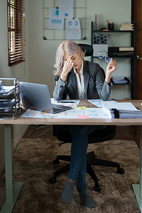 业务扩大摄影照片_中小企业主、使用计算机和财务报表的女性对扩大市场以提高投资业务能力的焦虑表达