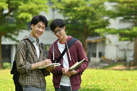 两个友好的学生在课后在大学校园的户外散步时互相交谈。
