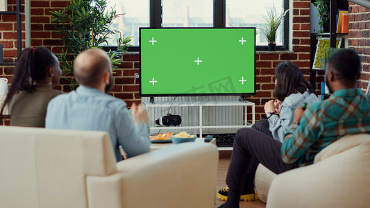 足球模板摄影照片_球迷在电视上使用绿屏观看足球比赛