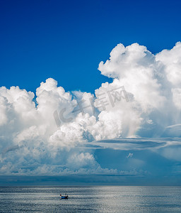 一艘船在大海中航行，天空中有一朵大云。