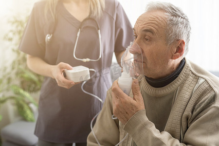 老年老人护理佩戴氧气吸入器帮助呼吸呼吸。