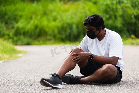 戴手表摄影照片_赛跑者黑人戴手表坐着他用双手联合握住