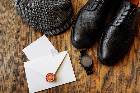 手表帽子摄影照片_男士服装套装，配有黑色经典鞋、手表和复古灰色帽子，与木制背景隔离。