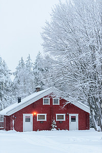 森林里的房子已经覆盖着大雪和糟糕的天空