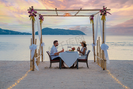 泰国普吉岛海滩上的浪漫晚餐，一对男女在海滩上共进晚餐