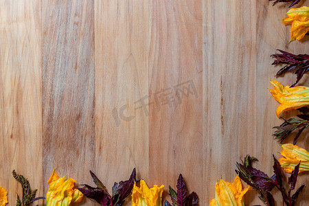 带南瓜花和紫色 epazote 的木质背景，用于复制空间