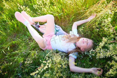 夏日玩乐摄影照片_一个漂亮的金发女孩在阳光明媚的夏日在草地上的草地上玩乐。