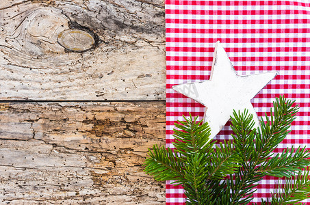 具有白色木星、杉树枝和红色方格织物背景的质朴圣诞背景
