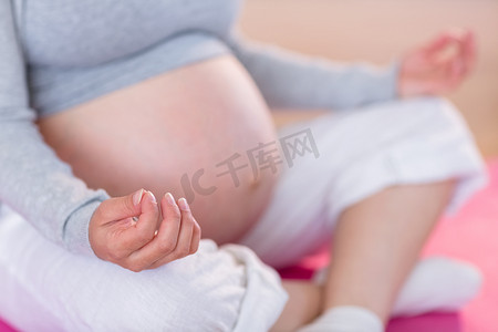 多人瑜伽摄影照片_在运动垫上做瑜伽的孕妇