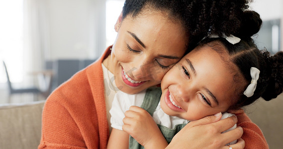快乐的母亲和孩子拥抱、亲吻和爱，在家里的客厅沙发上建立有趣的关系。