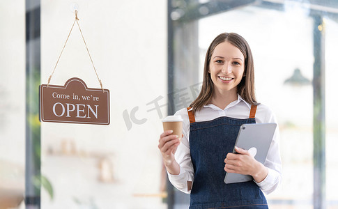 一位快乐的女服务员站在餐厅入口处的画像。