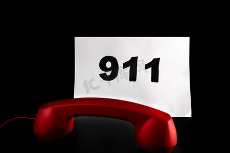 拨打 911 和紧急呼叫概念，在纸上发短信 911，在黑色上隔离电话。