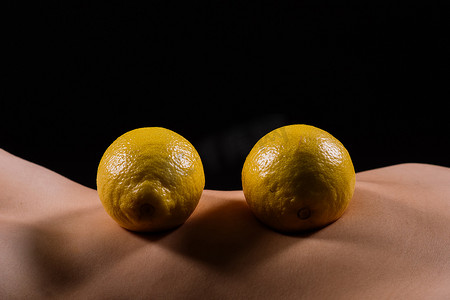 有橘皮组织问题的年轻女性和深色背景中的柠檬，特写