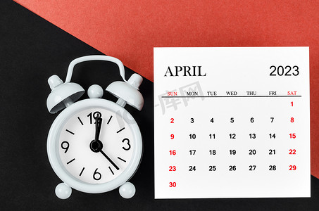 2023 年 4 月日历年，红色和黑色背景上有闹钟。