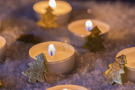 气氛金色摄影照片_寒冷的雪地上点着蜡烛和金色圣诞树的降临节和圣诞气氛