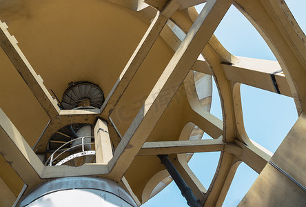 柱状图动画摄影照片_由水泥和金属螺旋楼梯制成的柱状结构旧水塔的自下而上视图。