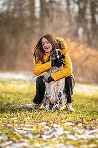 年轻的少女在大自然中和她的狗玩耍。
