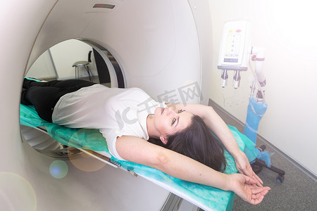 CT 扫描技术专家在准备手术过程中俯瞰计算机断层扫描仪中的患者。