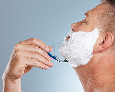 脱毛膏摄影照片_剃须刀、脸和带剃须膏的男人在工作室里隔离在灰色背景下，用于脱毛。