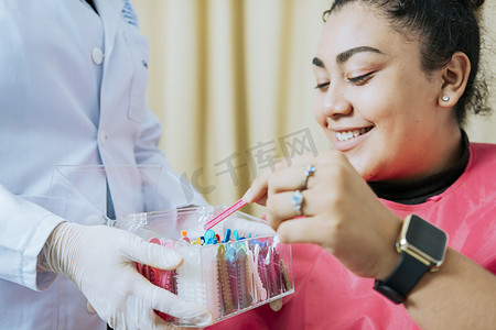 正畸病例摄影照片_牙科病人选择牙套，有牙医的病人选择彩色橡皮筋。