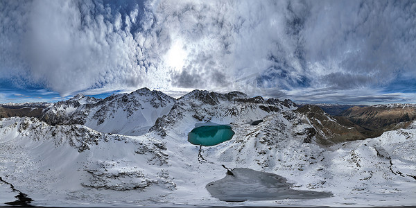 山区积雪覆盖的山脉全景与绿松石湖，阳光明媚的日子与云