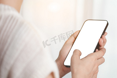 亚洲女性的手使用带有空白白屏的智能手机