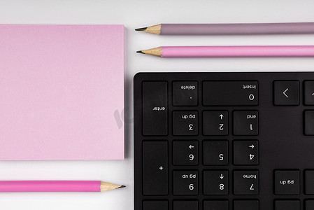 带有重要信息的彩色纸躺在靠近键盘的桌子上。