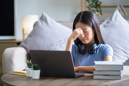 悲伤疲倦的头痛年轻亚洲青少年员工触摸头部、产后抑郁和紧张的担忧