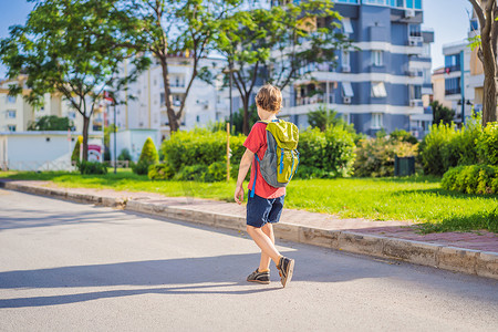 上学可爱摄影照片_背着背包的小男孩去上学。