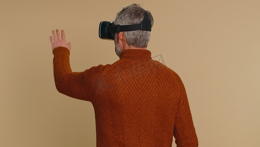 使用虚拟现实耳机头盔的老人玩模拟游戏应用，观看视频内容