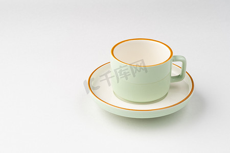 带有橙色轮廓的白色和淡绿色陶瓷茶杯