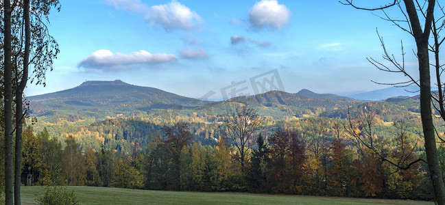 Luzicke hory 全景、草甸与秋天五颜六色的森林和树木和山丘与瞭望塔在山上 Hochwald Hvozd 和蓝天景观在 luzicke hory 山。