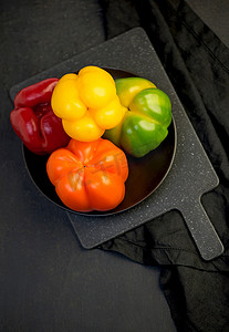 黄黑色背景摄影照片_黑色背景中的甜椒、红、绿、黄胡椒，全景深