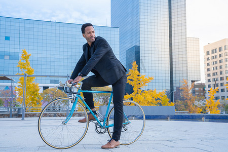 年轻时尚的商人去金融区前骑自行车上班。