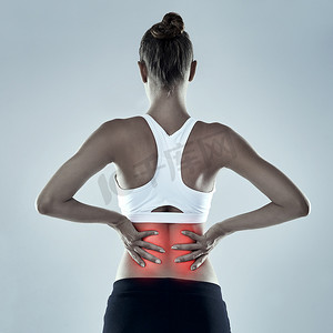 女性腰痛摄影照片_感觉她的腰有点痛。