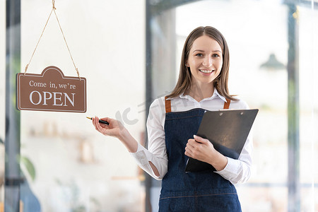 一位快乐的女服务员站在餐厅入口处的画像。