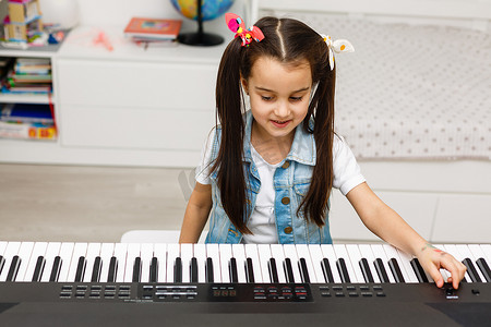 在家客厅弹钢琴的小女孩