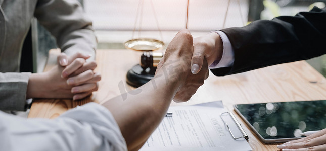 女律师手和男客户握手的特写在办公室与合同文件合作达成工作协议。