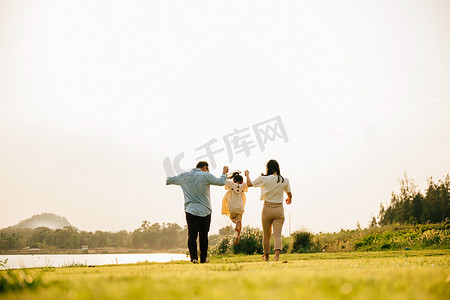 一群家庭在阳光明媚的公园里跑步和玩乐