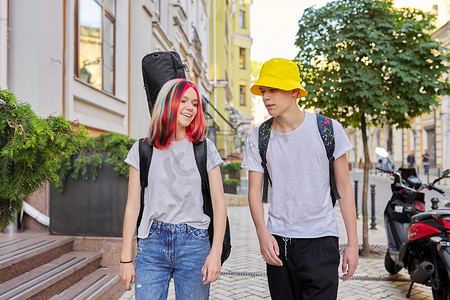 有创意的青少年男女在城市街道上行走和交谈