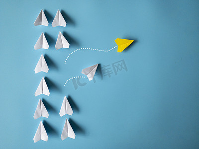 黄色和白色纸飞机折纸将其他白色飞机留在蓝色背景上，并带有可定制的文本空间。