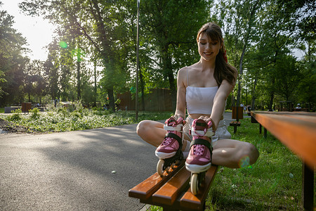 一个穿着运动服的女孩盘腿坐在长椅上。