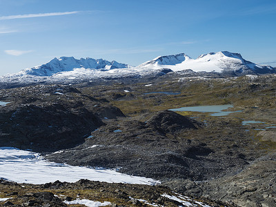 从 Krossbu 欣赏挪威西部 Jotunheimen 国家公园的 Smorstabbreen 冰川、雪山和蓝色湖泊的全景