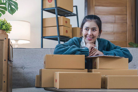 物流dm单摄影照片_肖像年轻迷人的亚洲女性所有者创业公司工作快乐与家里的盒子在 sme 供应链中准备包裹递送，启动小企业概念。