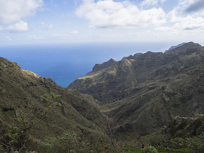 海平线摄影照片_特内里费阿纳加山的熔岩悬崖，绿色植被小，蓝色海平线，天空白云