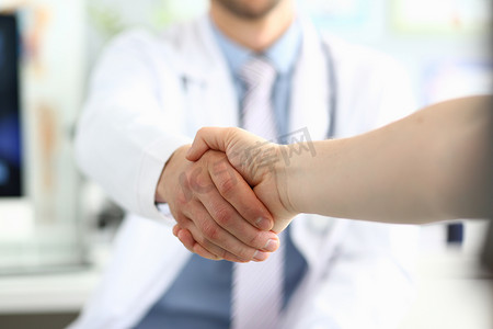 医生在诊所与病人握手并感谢握手的出色治疗
