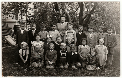 复古照片显示同学（大约 10 岁）和老师