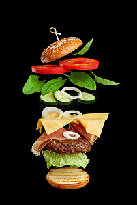 肉排摄影照片_飞行汉堡原料：炸肉排、芝麻包、番茄、洋葱