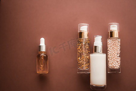 棕色背景中的护肤化妆品和抗衰老美容产品、豪华护肤瓶、油、血清和面霜