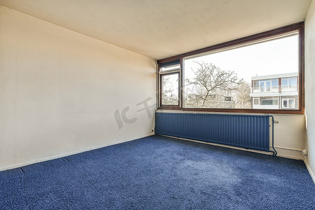 有大窗户和蓝色地毯的空房间